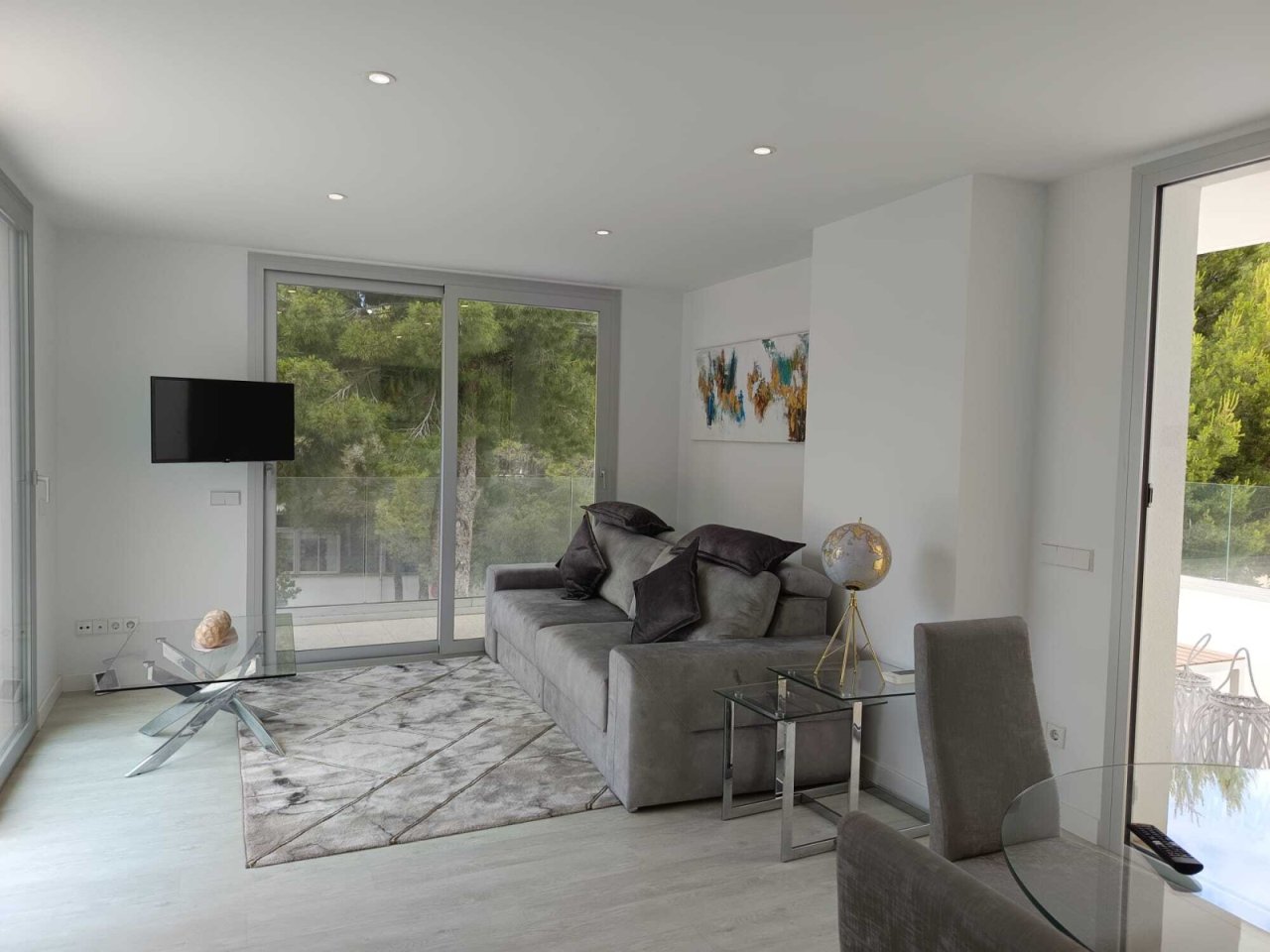 Helles Wohnzimmer mit großflächigen Glasschiebetüren und Zugang zur Terrasse Helles Wohnzimmer mit großflächigen Glasschiebetüren und Zugang zur Terrasse