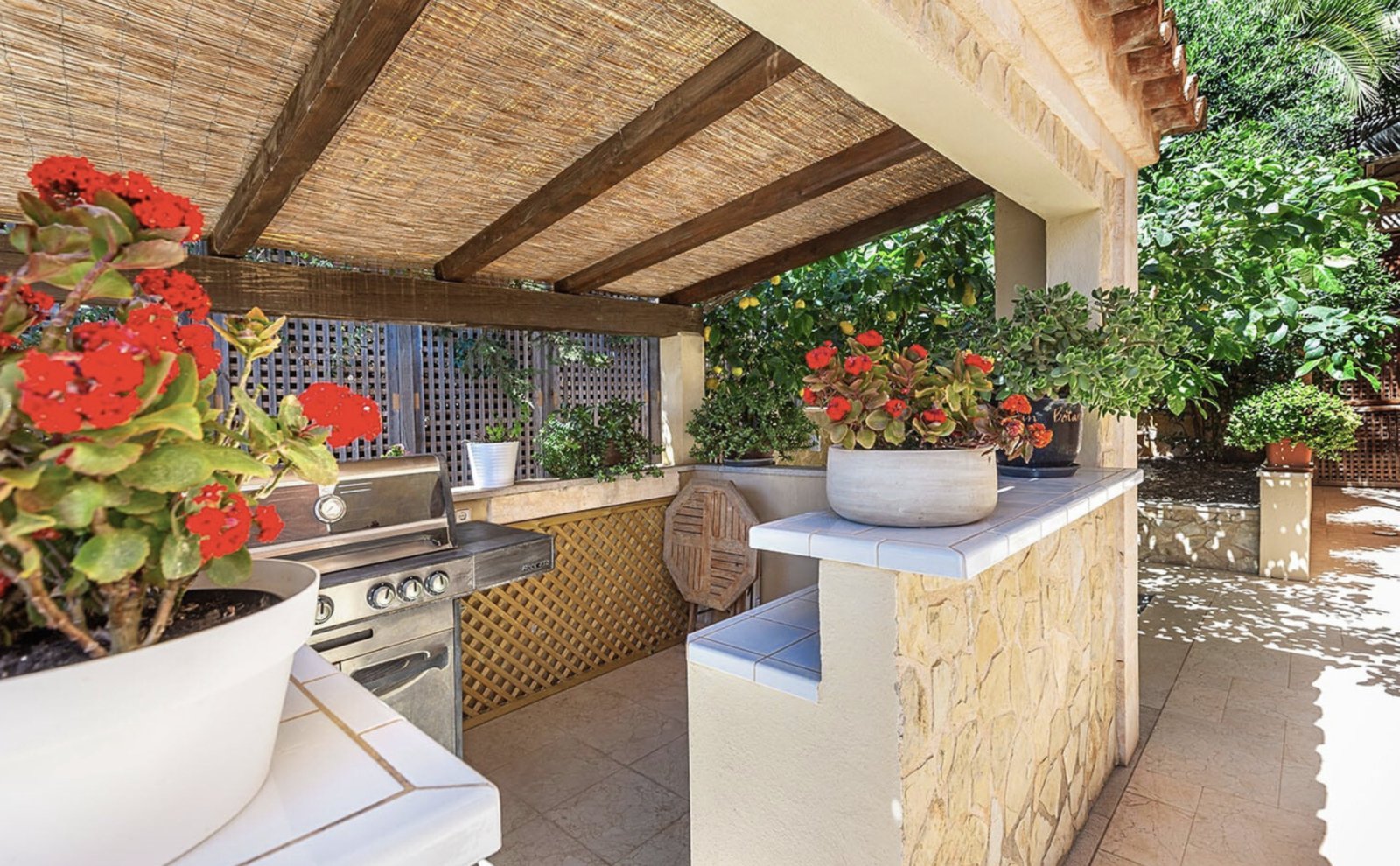 Überdachte Außenküche mit integriertem Grill und funktionalem Küchenblock – perfekt für Outdoor-Entertaining