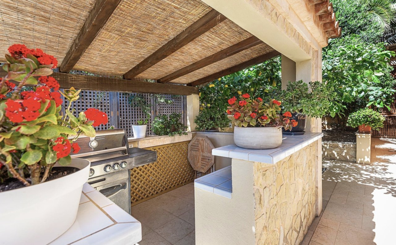 Überdachte Außenküche mit integriertem Grill und funktionalem Küchenblock – perfekt für Outdoor-Entertaining