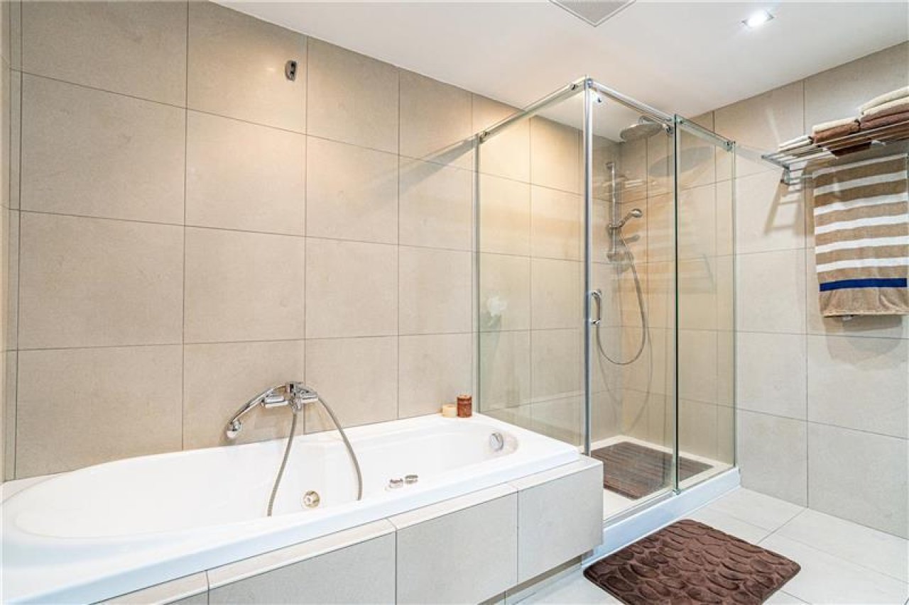 Wellness-Bad mit freistehender Wanne und begehbarer Dusche mit Glasabtrennung