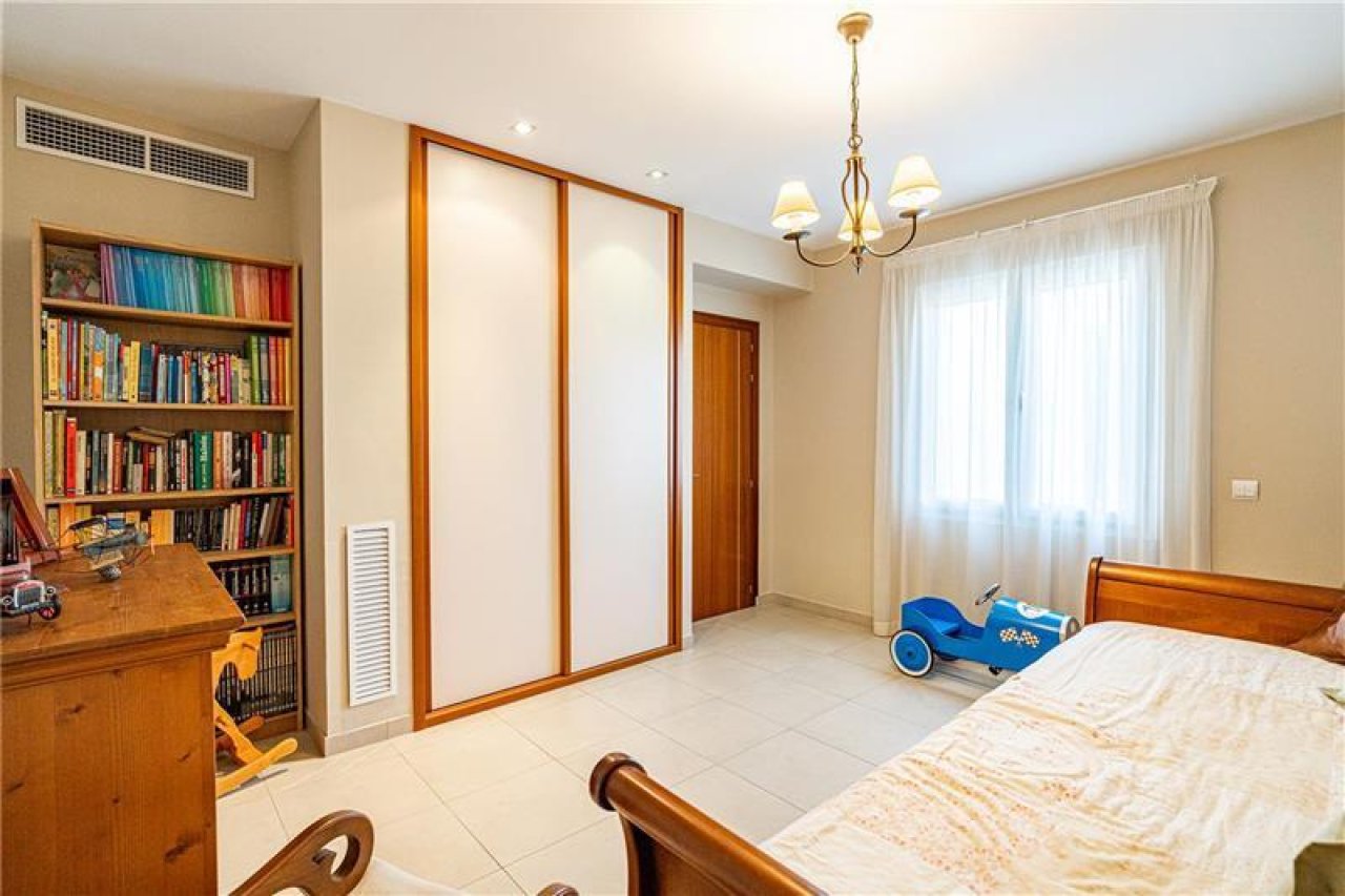 Geräumiges Schlafzimmer mit integriertem Ankleidebereich und bodentiefen Fenstern