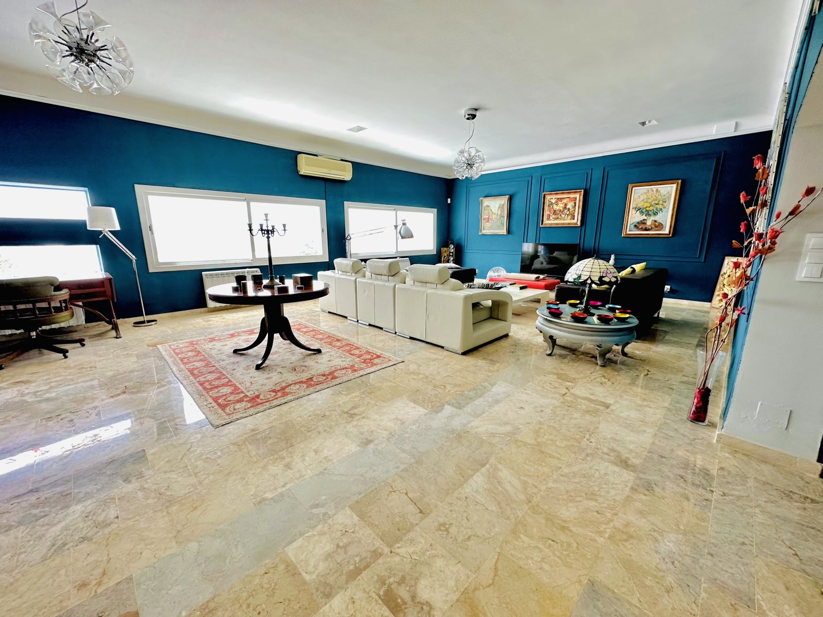 Elegantes Wohnzimmer mit Marmorboden und großflächiger Fensterfront Elegantes Wohnzimmer mit Marmorboden und großflächiger Fensterfront