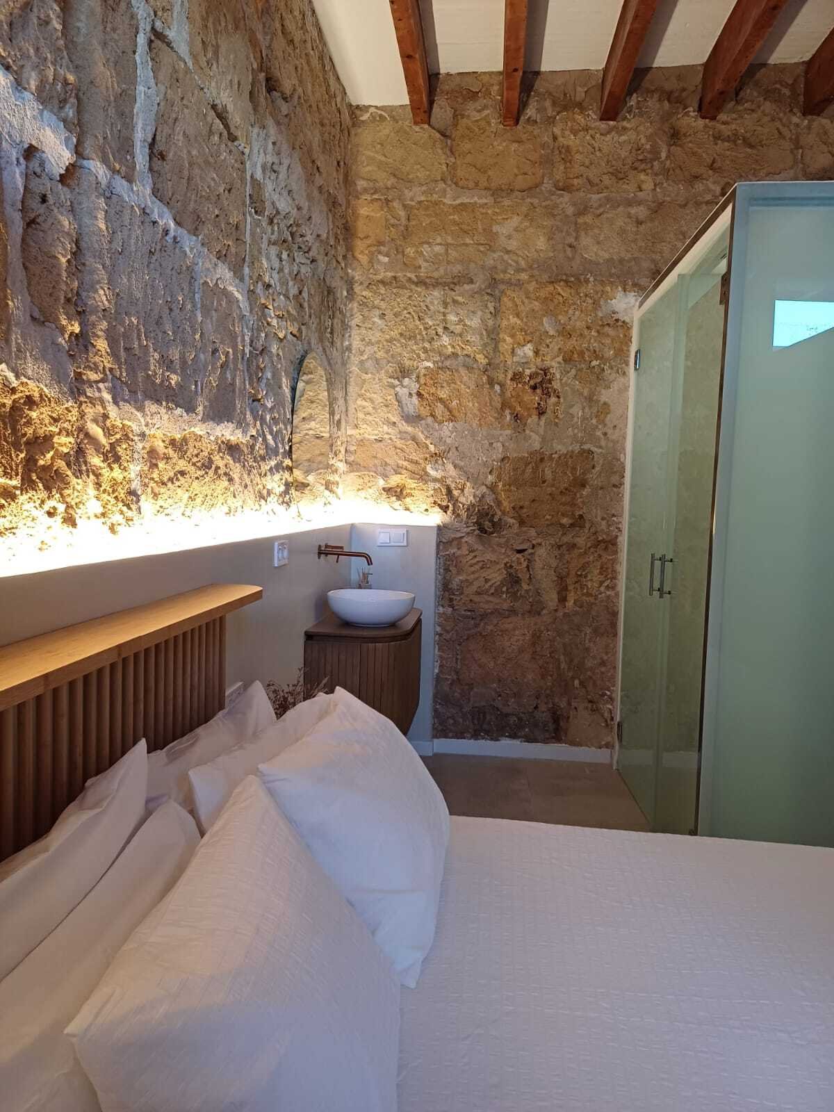Ensuite-Badezimmer mit begehbarer Dusche – Privates Wellness-Areal mit authentischen Steinwänden