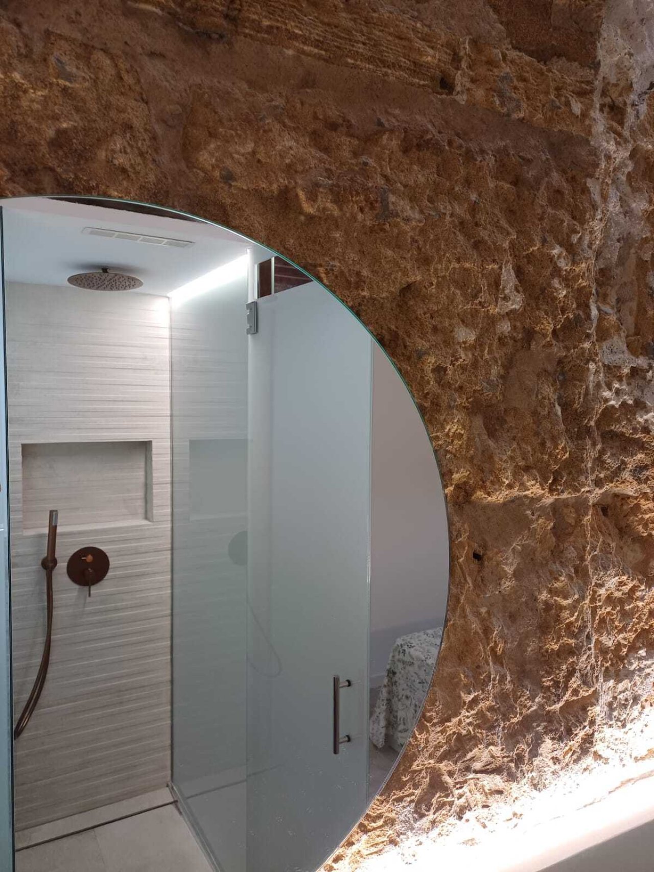 Luxuriöse Duschanlage mit Regendusche und Nischenablage – Spa-Feeling in authentischem Steinambiente