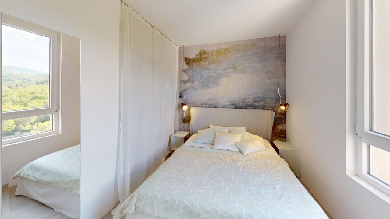 Helles Schlafzimmer mit Panoramafenstern und Landschaftsblick Helles Schlafzimmer mit Panoramafenstern und Landschaftsblick
