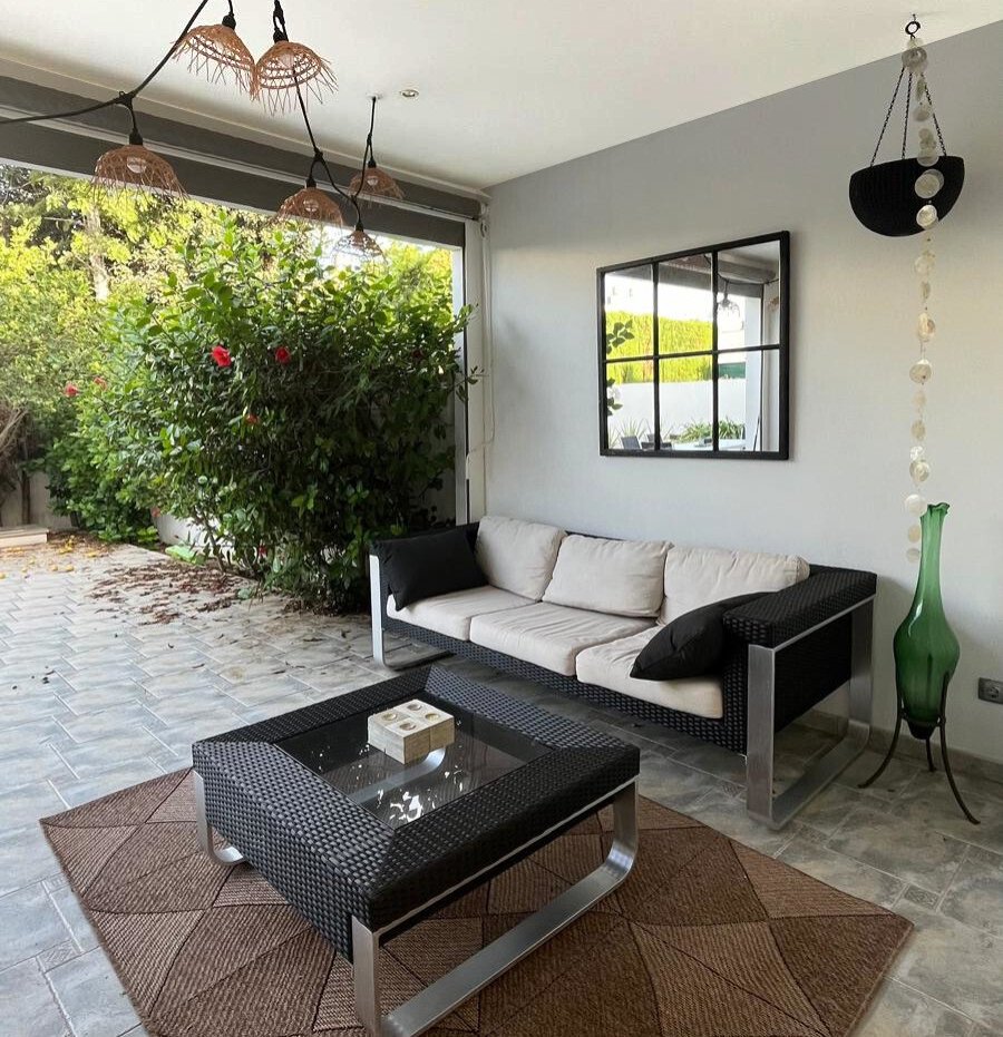 Überdachte Lounge-Terrasse mit großflächigen Glasschiebetüren und nahtlosem Übergang zum privaten Gartenbereich Überdachte Lounge-Terrasse mit großflächigen Glasschiebetüren und nahtlosem Übergang zum privaten Gartenbereich