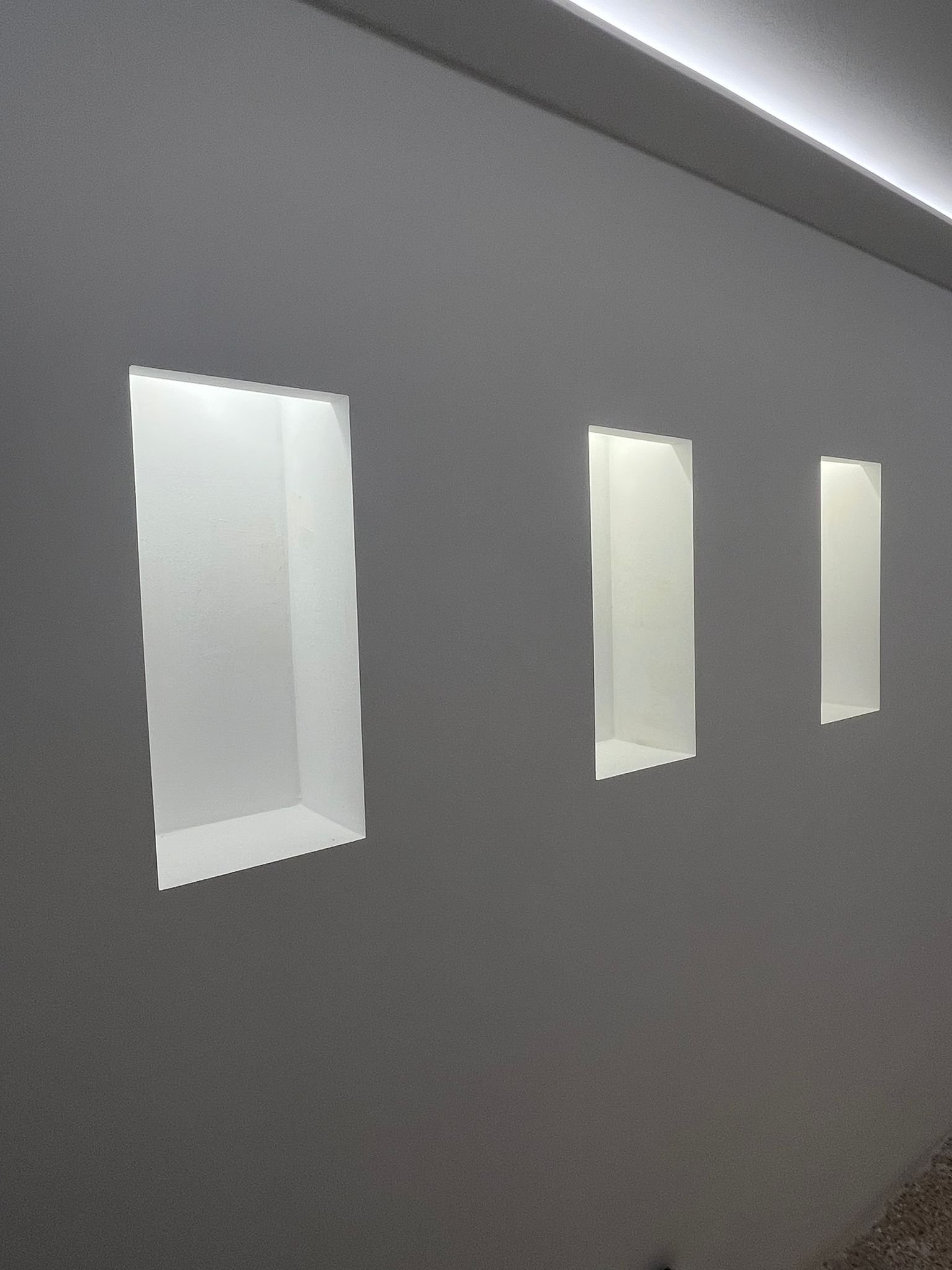 Elegante Wandnischen mit integrierter LED-Akzentbeleuchtung und moderner Rauminszenierung Elegante Wandnischen mit integrierter LED-Akzentbeleuchtung und moderner Rauminszenierung