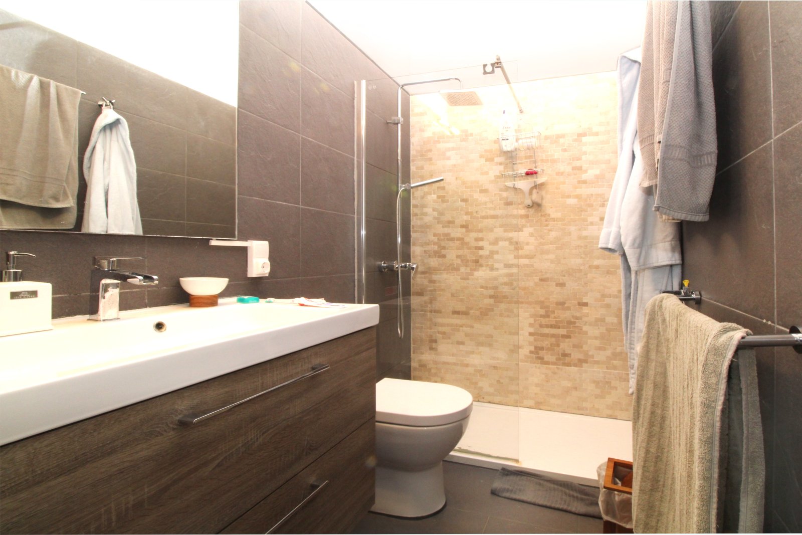 Modernes Badezimmer mit ebenerdiger Dusche und hochwertiger Sanitärausstattung
