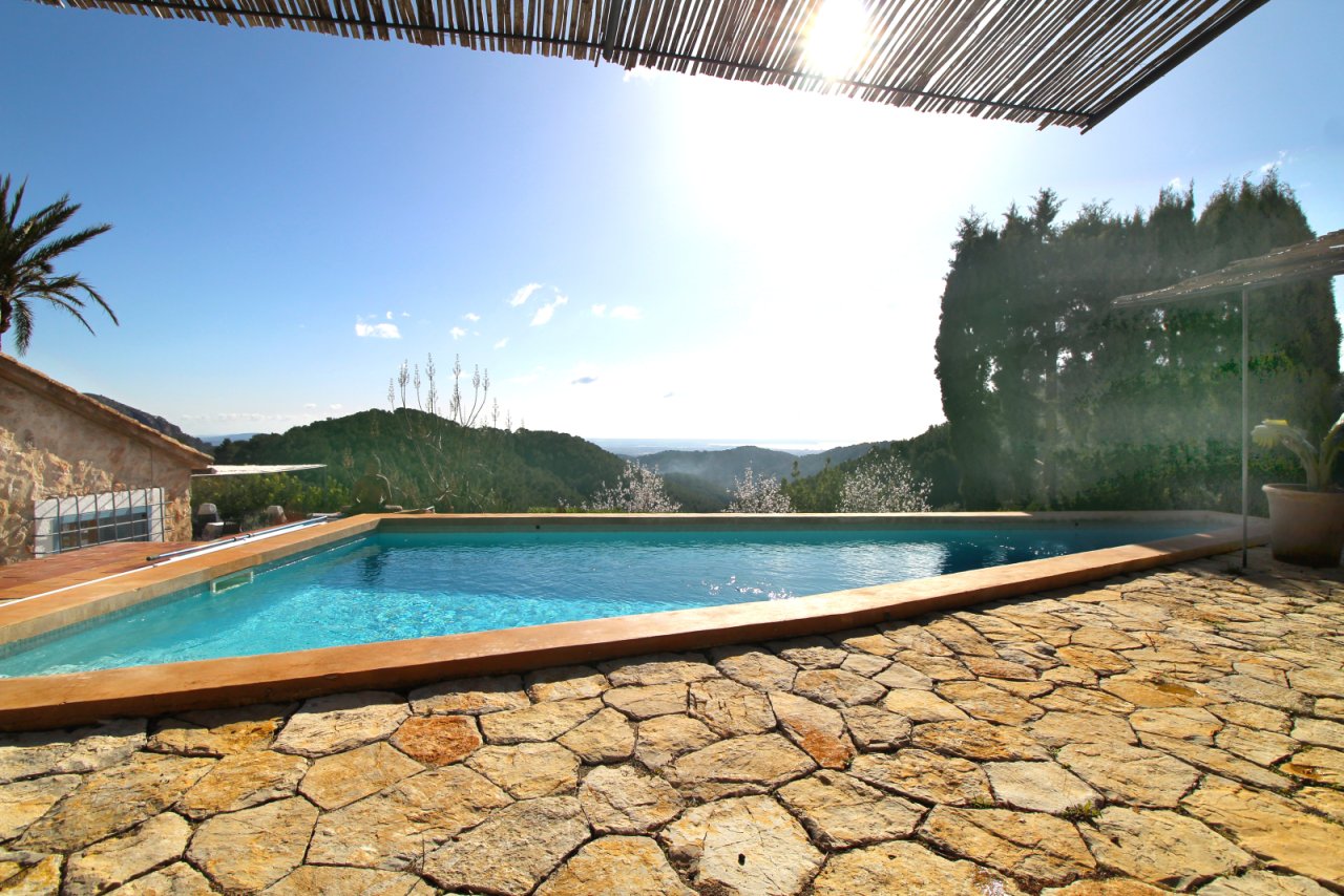 Infinity-Pool mit Natursteinterrasse und ungehindertem Bergpanorama