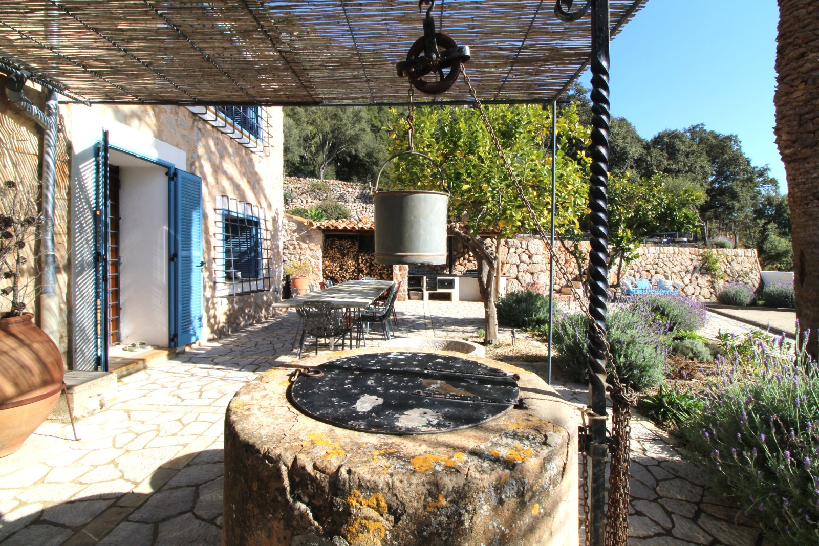 Terrassenbereich mit massiver Brunnenanlage, Pergola-Überdachung und idyllischem Gartenambiente