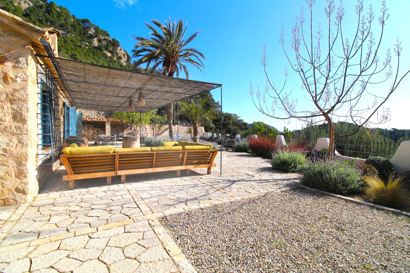 Terrassenanlage mit Sonnenschutz-Pergola und weitläufiger Freifläche zum Entspannen