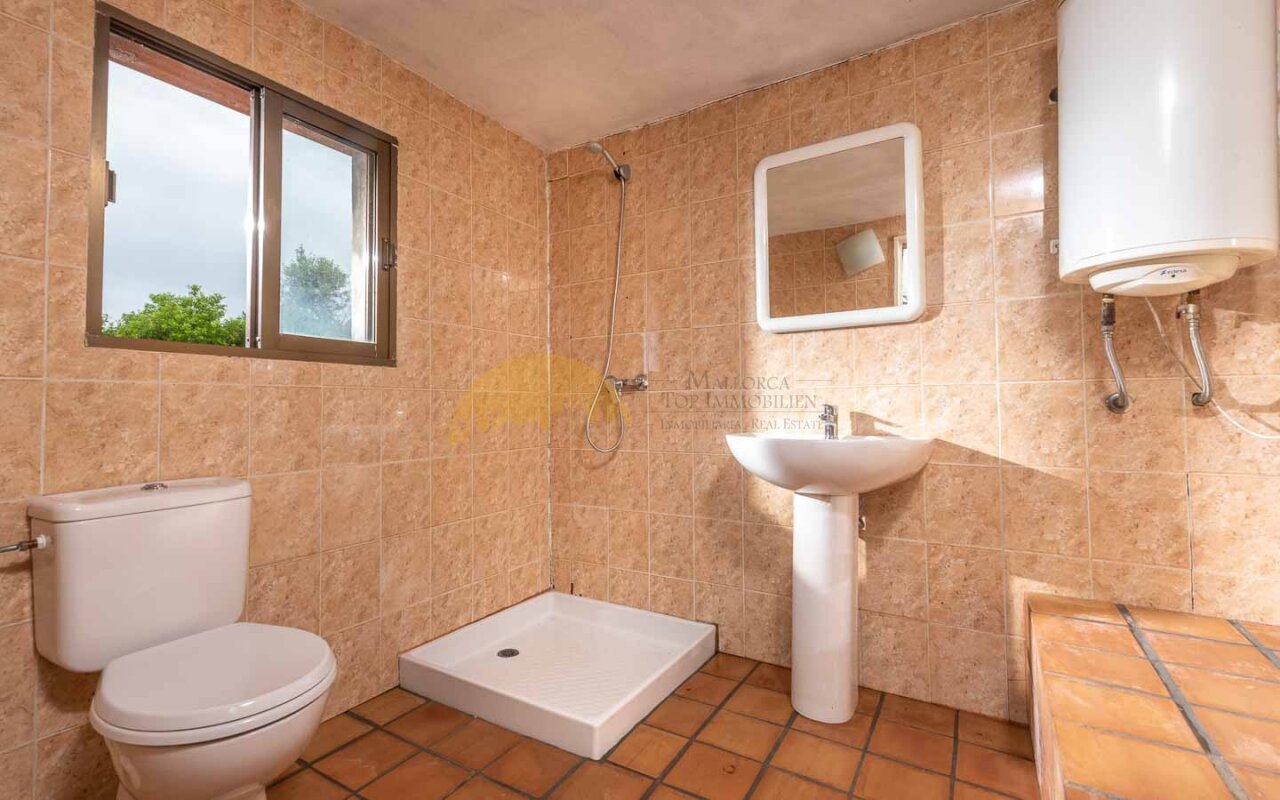 Helles Badezimmer mit Fenster und bodengleicher Dusche – Praktische Ausstattung mit Handtuchwärmer und Spiegelschrank