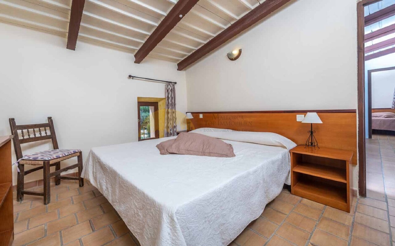 Schlafzimmer mit Holzbalkendecke und direktem Terrassenzugang – Rustikales Flair mit komfortabler Raumhöhe