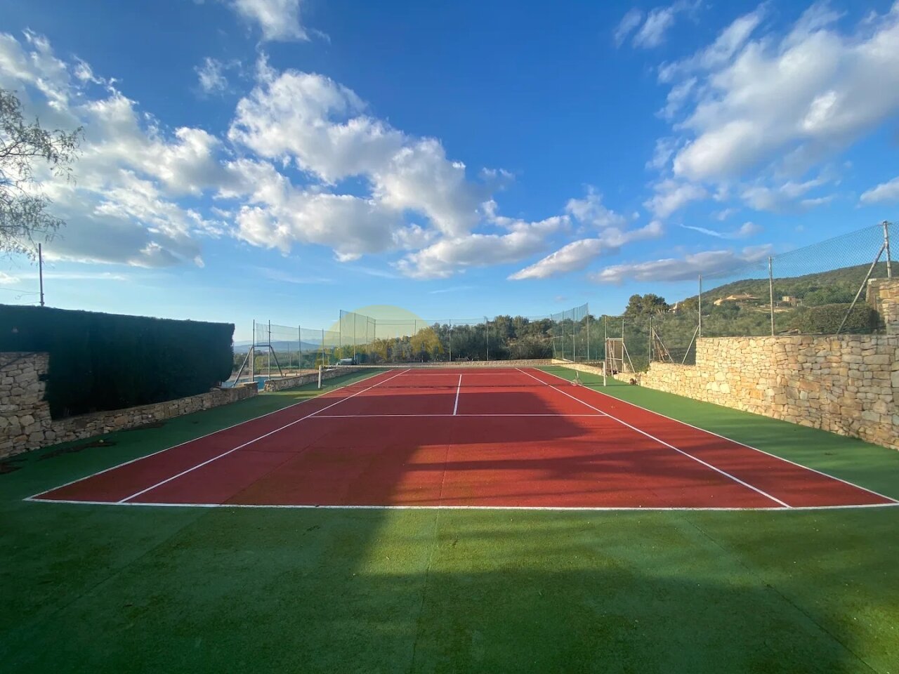 Tennisplatz in Wettkampfqualität – Professionelle Sportanlage mit Ballfangzäunen und optimaler Flutlichtausstattung