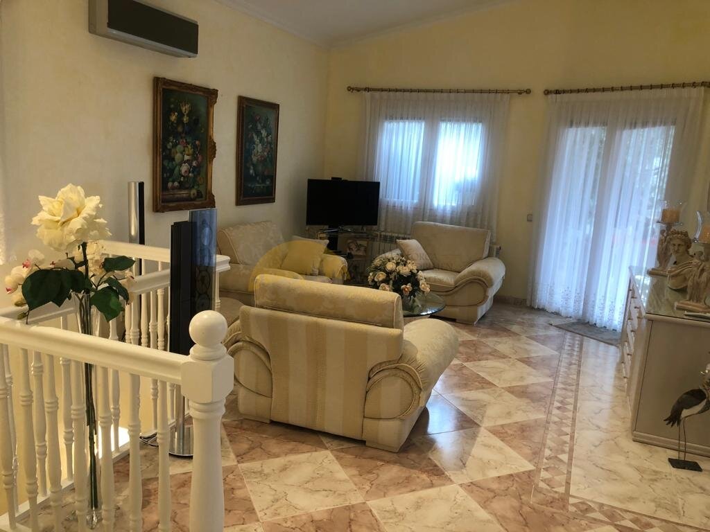 Helles Wohnzimmer mit Marmorboden und direktem Zugang zur Terrasse
