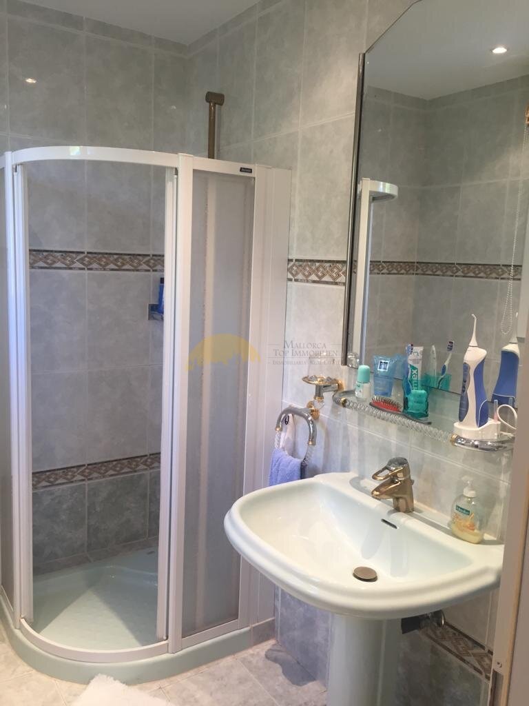 Modernes Badezimmer mit begehbarer Duschkabine und hochwertigem Fliesendesign