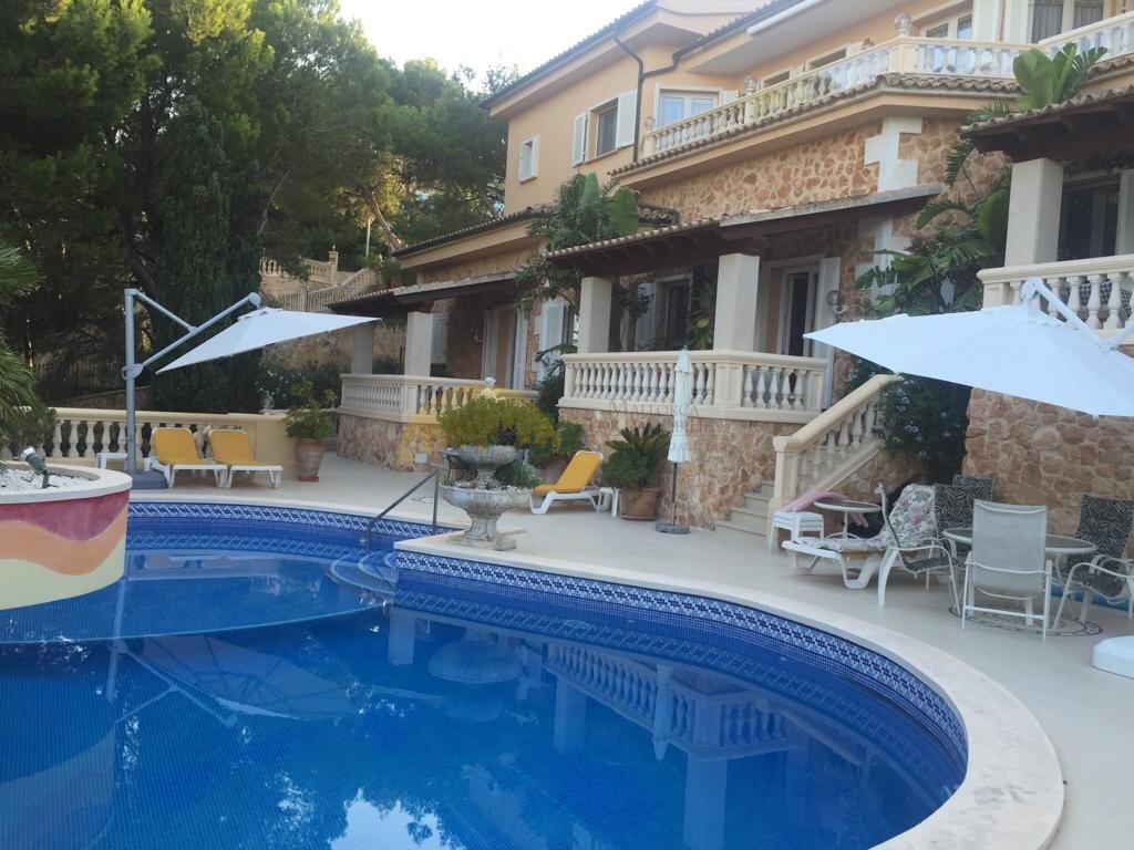 Poolbereich mit eleganten Sonnensegeln und mehreren Terrassen-Ebenen