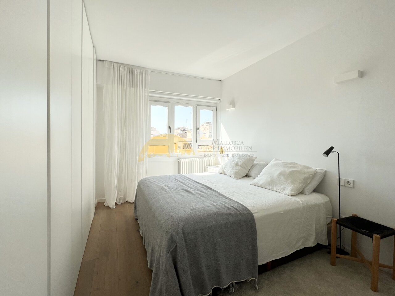 Helles Schlafzimmer mit direktem Balkonzugang und raumhohen Einbauschränken