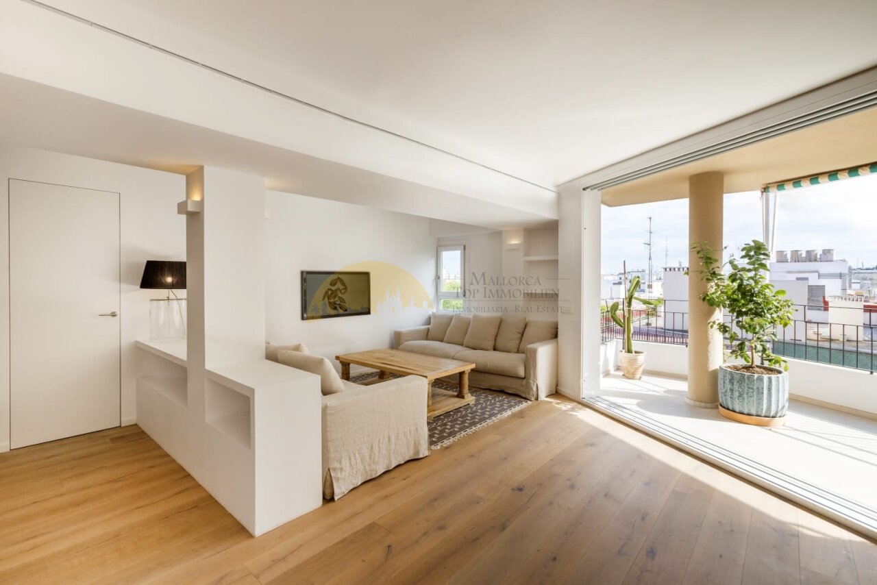 Helles Wohnzimmer mit großflächigen Glasschiebetüren und Panoramablick auf die Terrasse