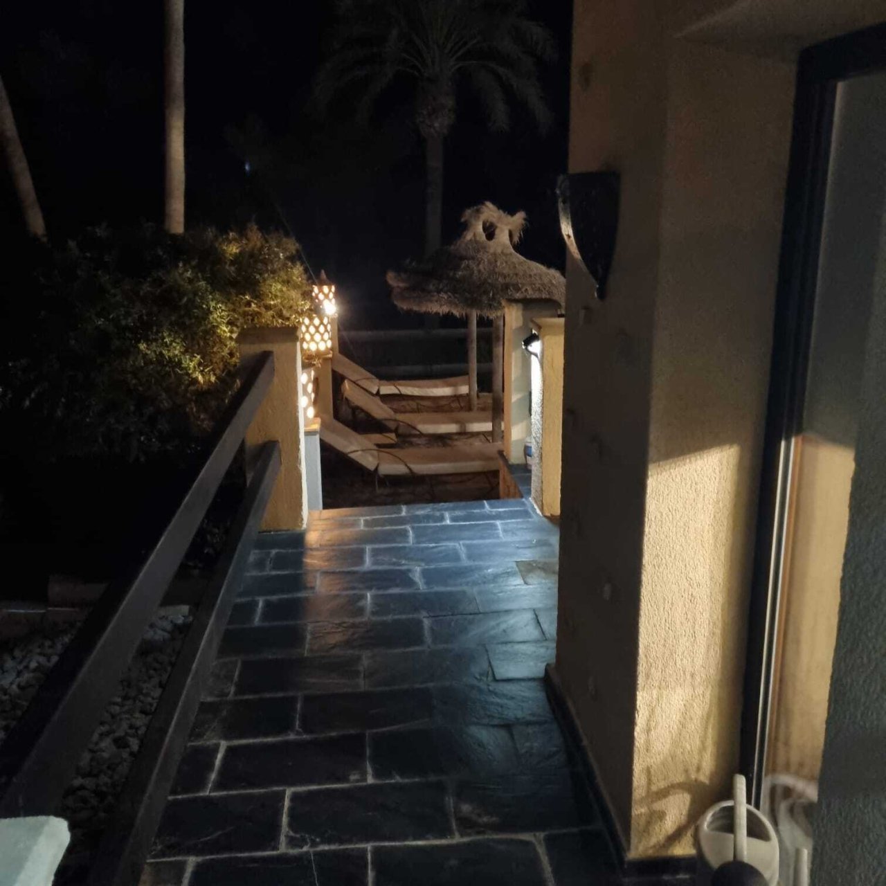 Elegante Terrassenpassage mit hochwertigen Natursteinbelägen und stimmungsvoller Nachtbeleuchtung Elegante Terrassenpassage mit hochwertigen Natursteinbelägen und stimmungsvoller Nachtbeleuchtung