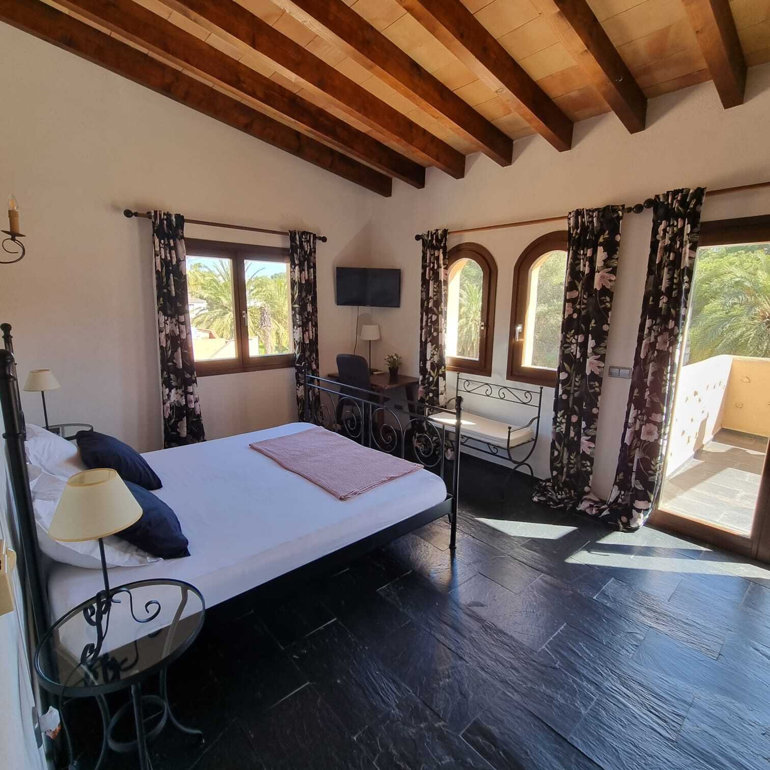 Hauptschlafzimmer mit charaktervoller Holzbalkendecke, mehrfachen Terrassenzugängen und reichlich Tageslicht Hauptschlafzimmer mit charaktervoller Holzbalkendecke, mehrfachen Terrassenzugängen und reichlich Tageslicht