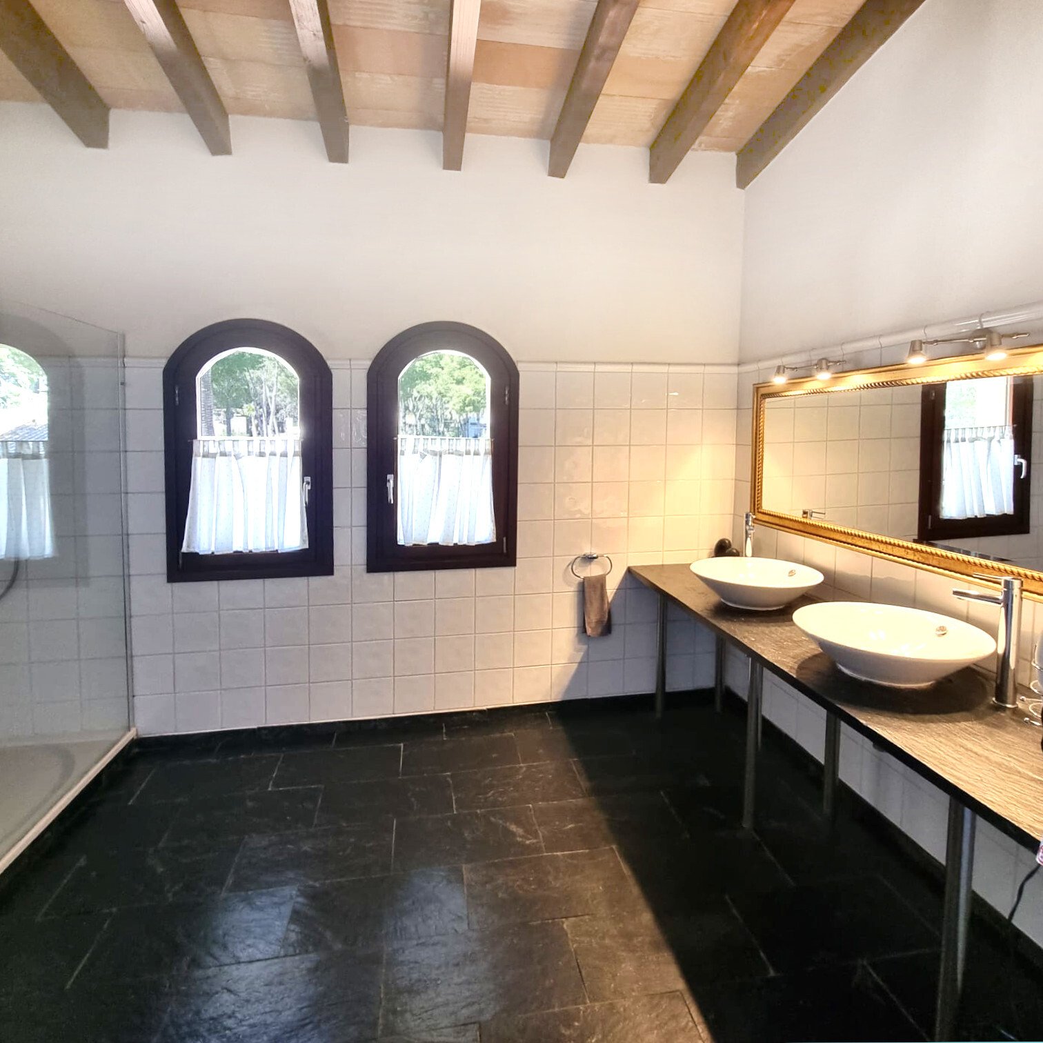 Elegantes Badezimmer mit Doppelwaschtisch, begehbarer Dusche und natürlicher Belichtung Elegantes Badezimmer mit Doppelwaschtisch, begehbarer Dusche und natürlicher Belichtung
