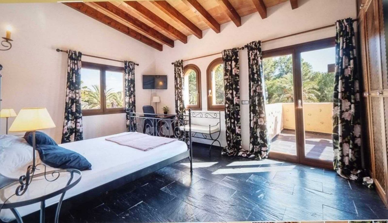 Hauptschlafzimmer mit Balkonzugang, Holzbalkendecke und großflächigen Fenstern Hauptschlafzimmer mit Balkonzugang, Holzbalkendecke und großflächigen Fenstern