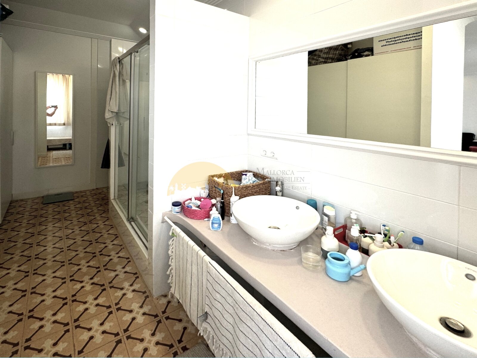 Luxuriöses Badezimmer mit Doppelwaschtisch, großflächigem Spiegel und begehbarer Dusche