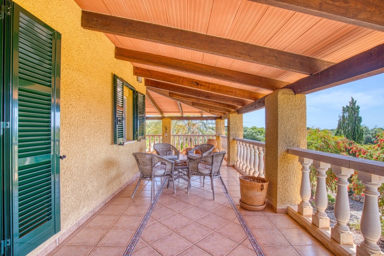 Überdachte Loggia mit massiven Holzbalken und freiem Panoramablick über die Landschaft