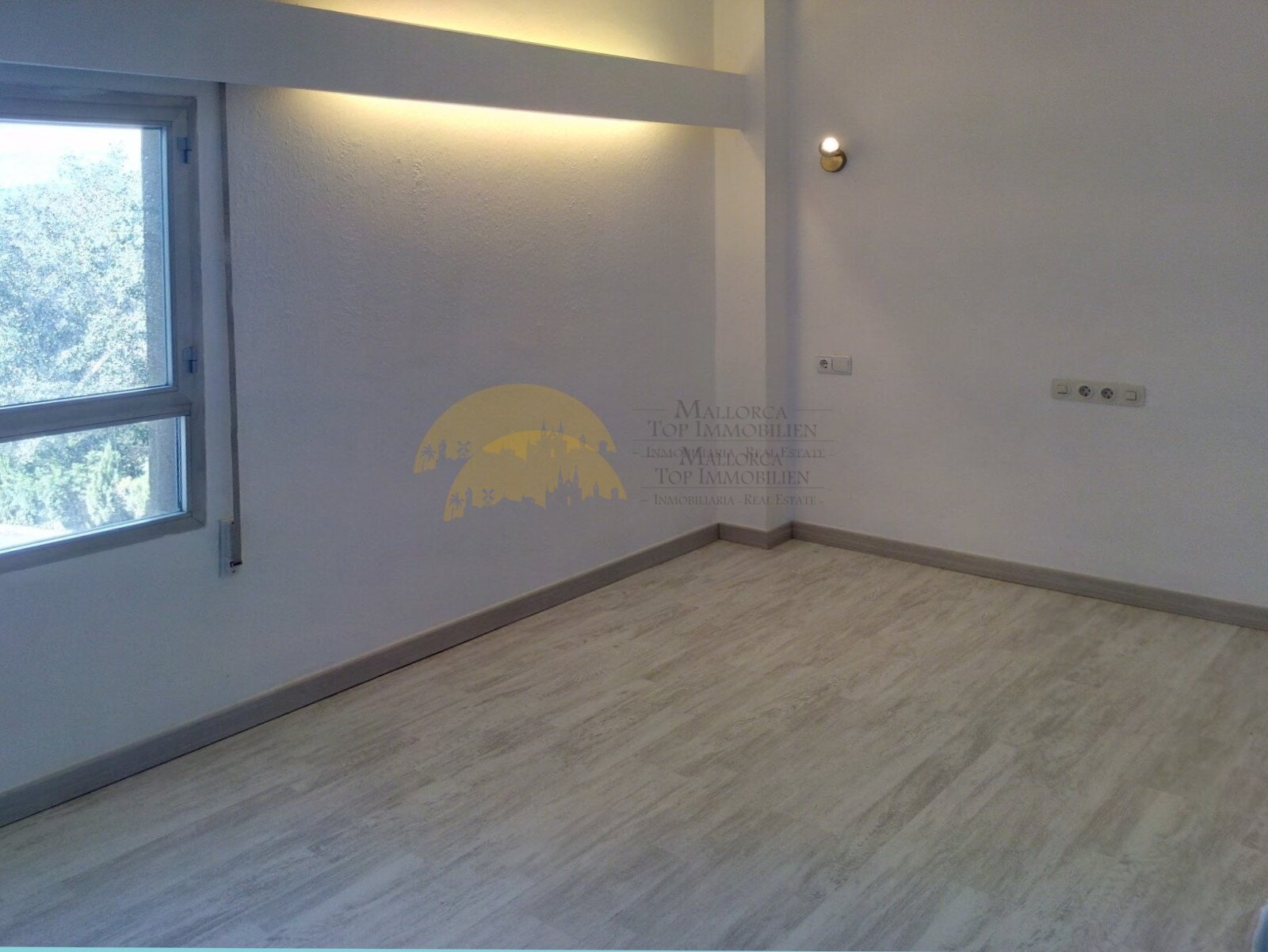 Helles Zimmer mit großflächigem Fenster und moderner Bodenbelaggestaltung Helles Zimmer mit großflächigem Fenster und moderner Bodenbelaggestaltung