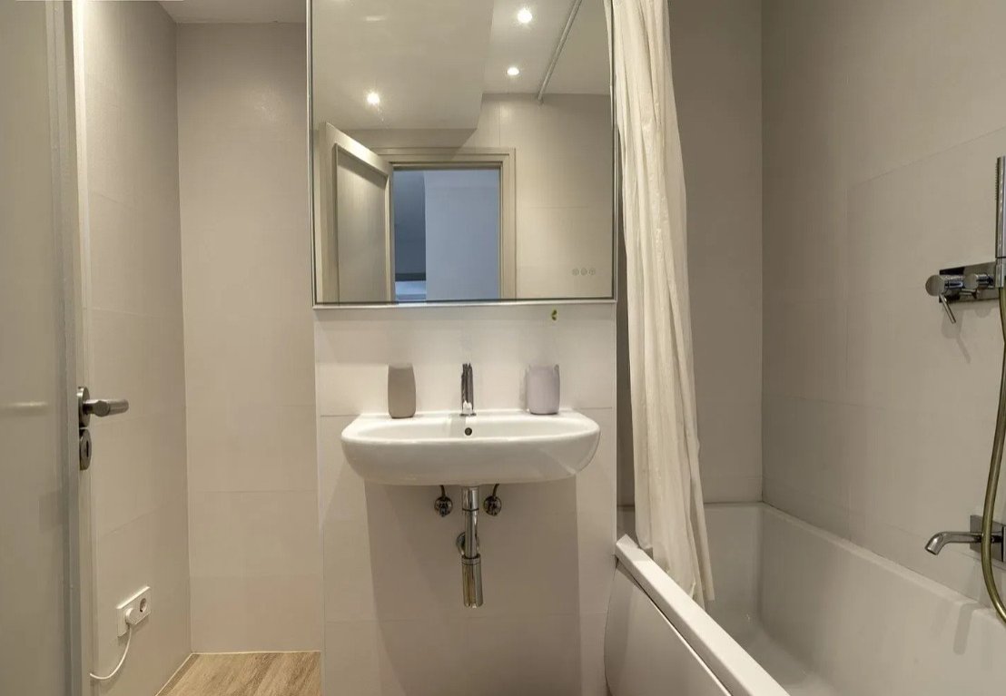 Modernes Badezimmer mit großem Spiegel und funktionaler Ausstattung