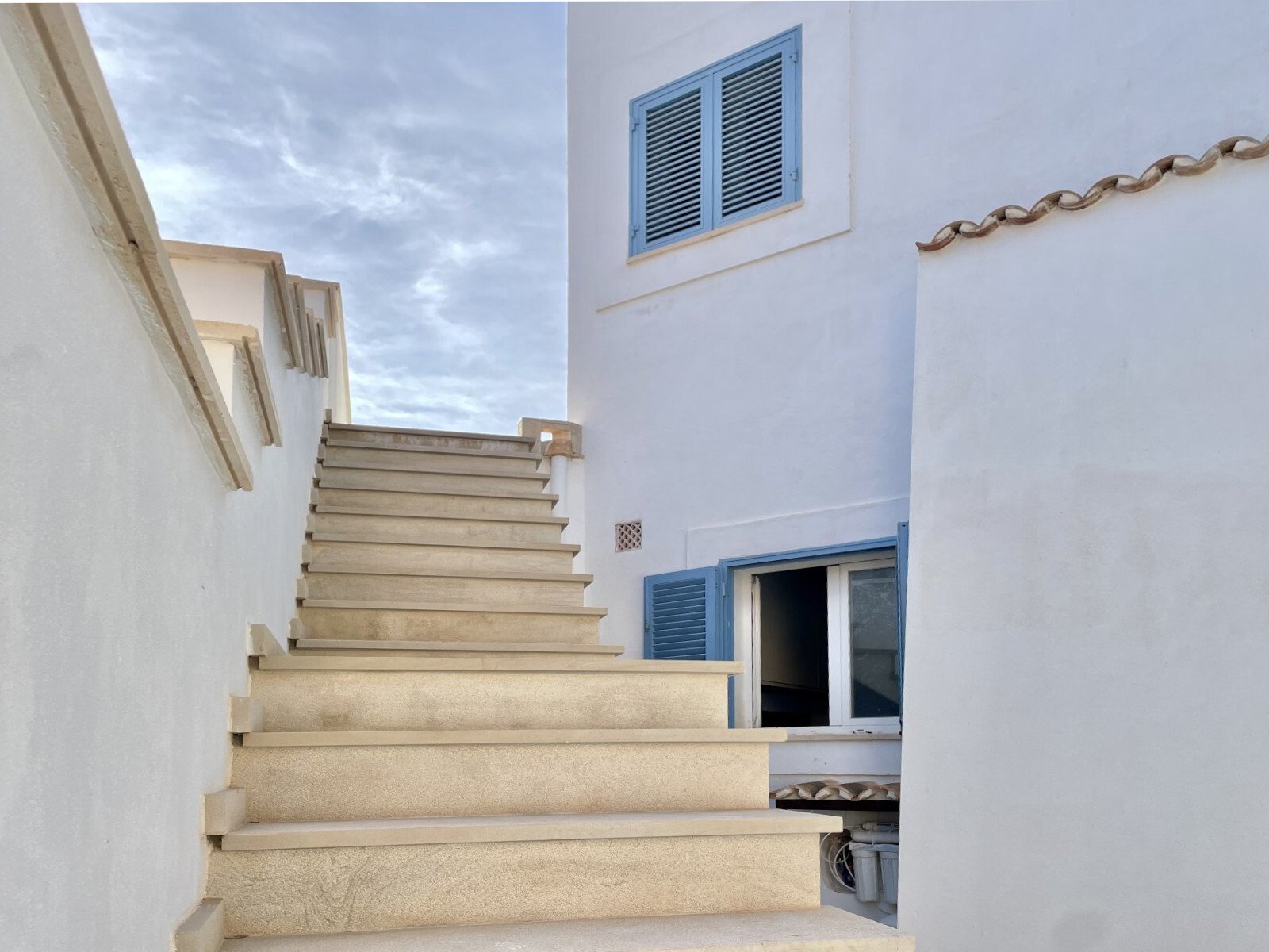 Elegant natural stone staircase with direct access to living areas and terrace Elegant natural stone staircase with direct access to living areas and terrace