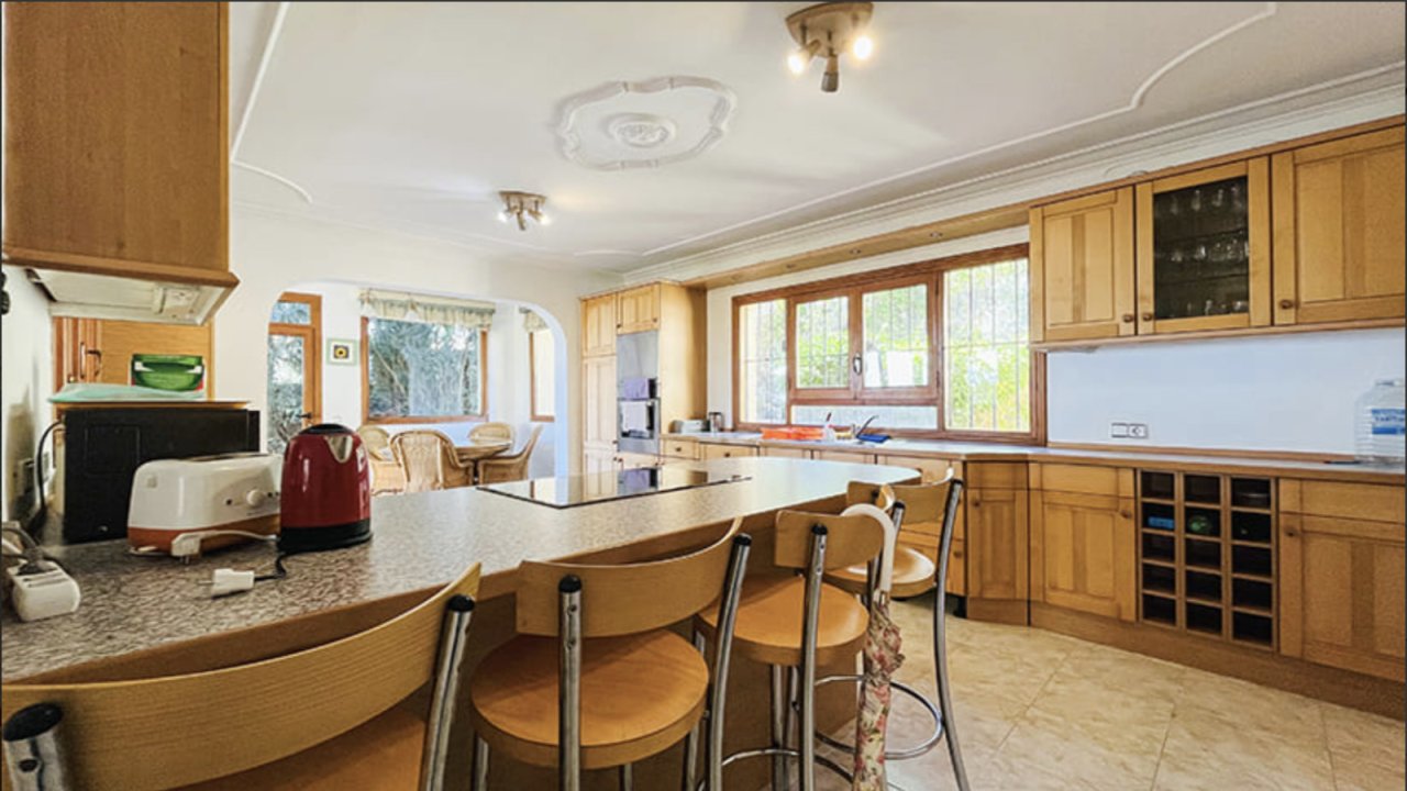 Open kitchen with a central island and large window front to the garden Open kitchen with a central island and large window front to the garden