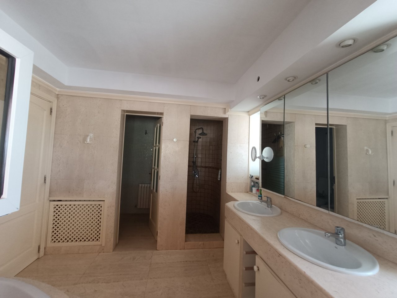 Luxurious bathroom with double vanity and large mirror system – spacious wet area with high-quality fittings