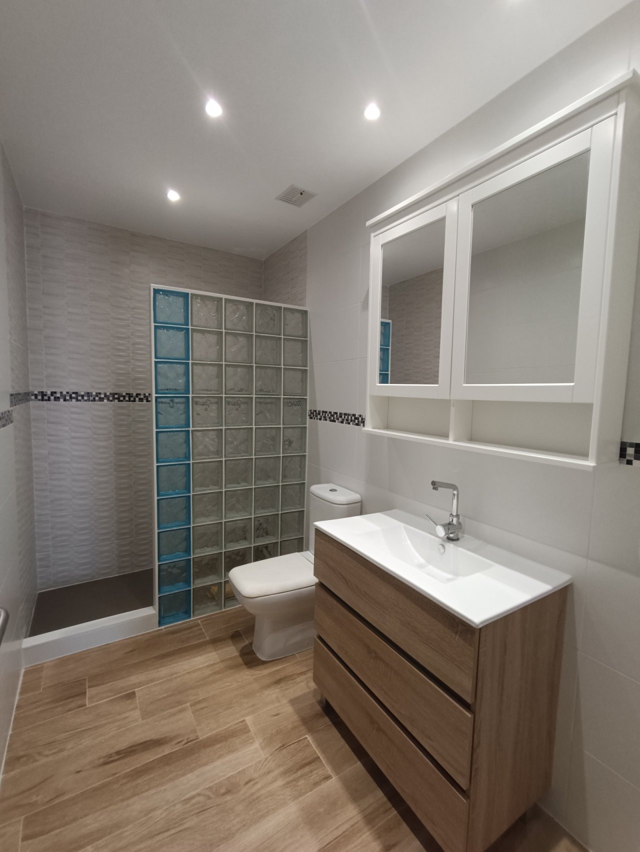 Modern bathroom with walk-in shower and large mirror cabinet – functionally designed wet area with high-quality fittings