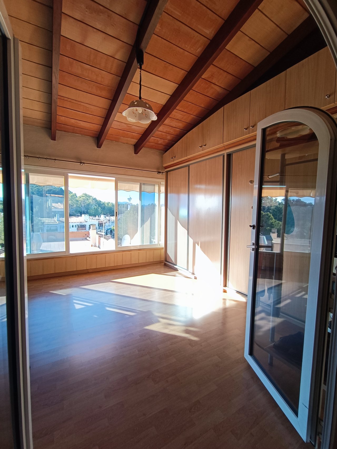 Panoramic view from the living area – floor-to-ceiling windows with a view and distinctive wooden beams