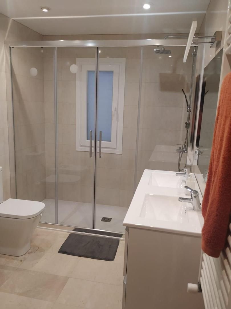 Modern bathroom with walk-in shower, double washbasin, and high-quality sanitary fittings