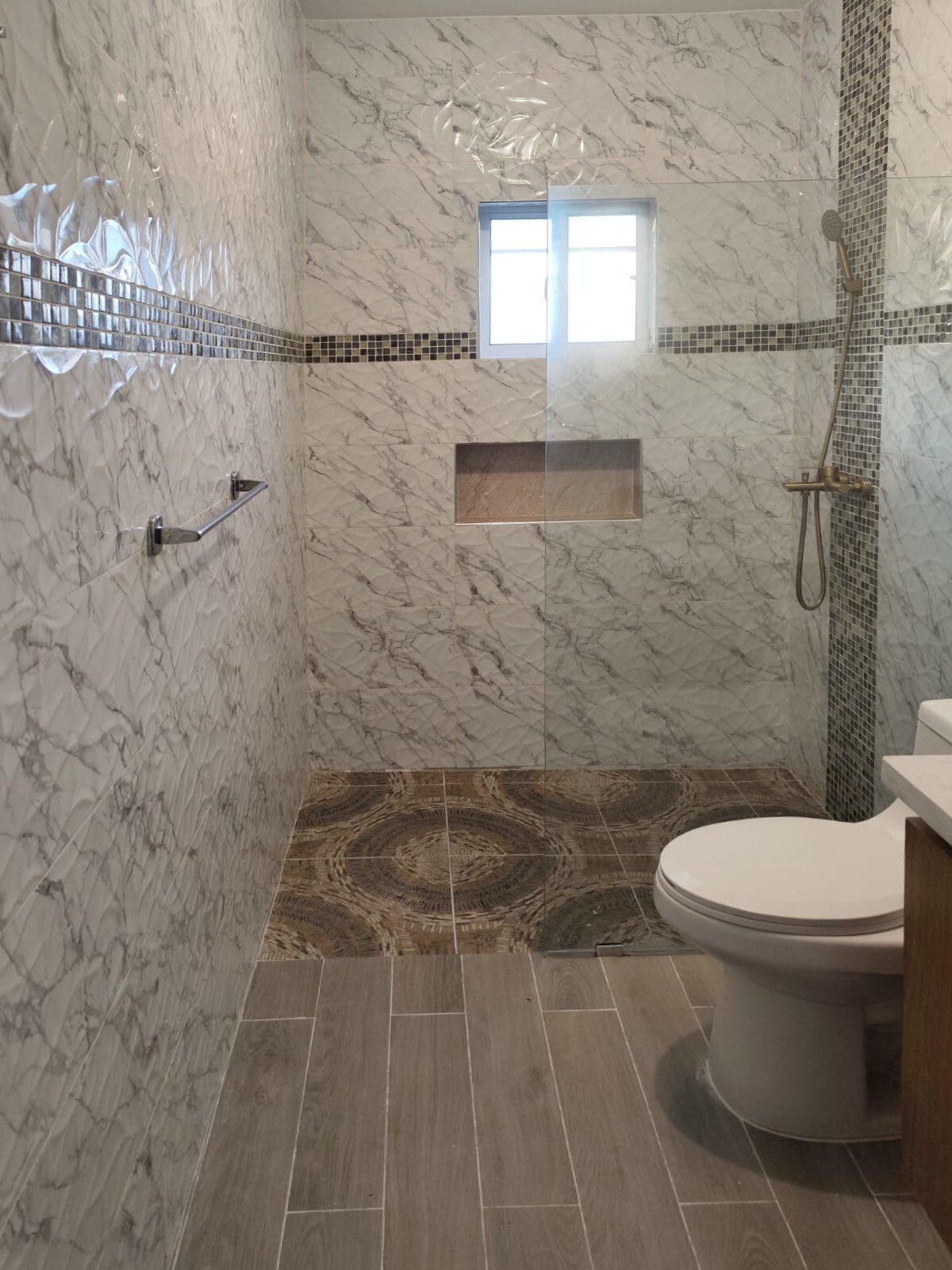 Luxurious shower bath with marble cladding and a walk-in shower with glass partition Luxurious shower bath with marble cladding and a walk-in shower with glass partition