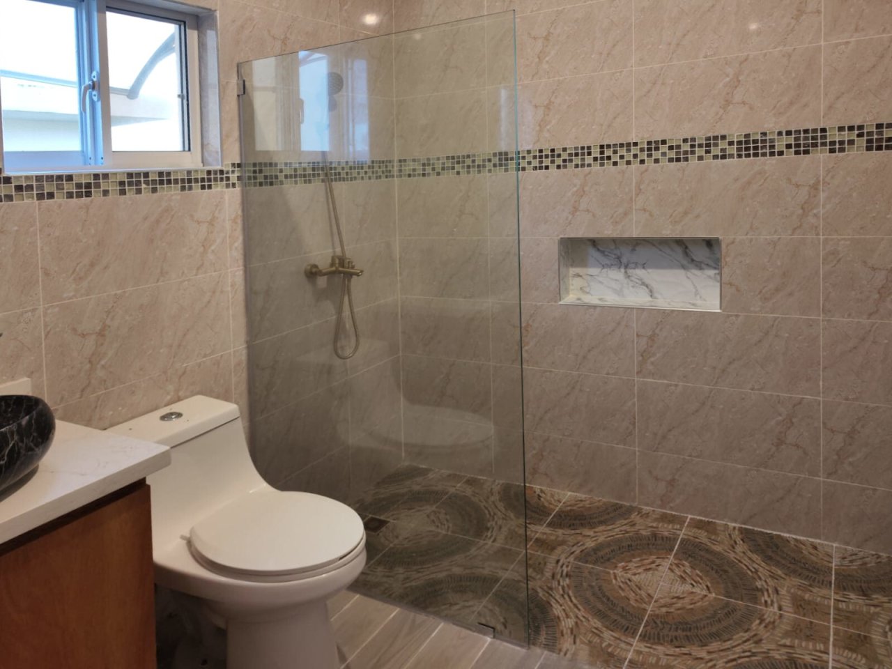 Modern bathroom with walk-in shower, niche solution, and window ventilation. Modern bathroom with walk-in shower, niche solution, and window ventilation.