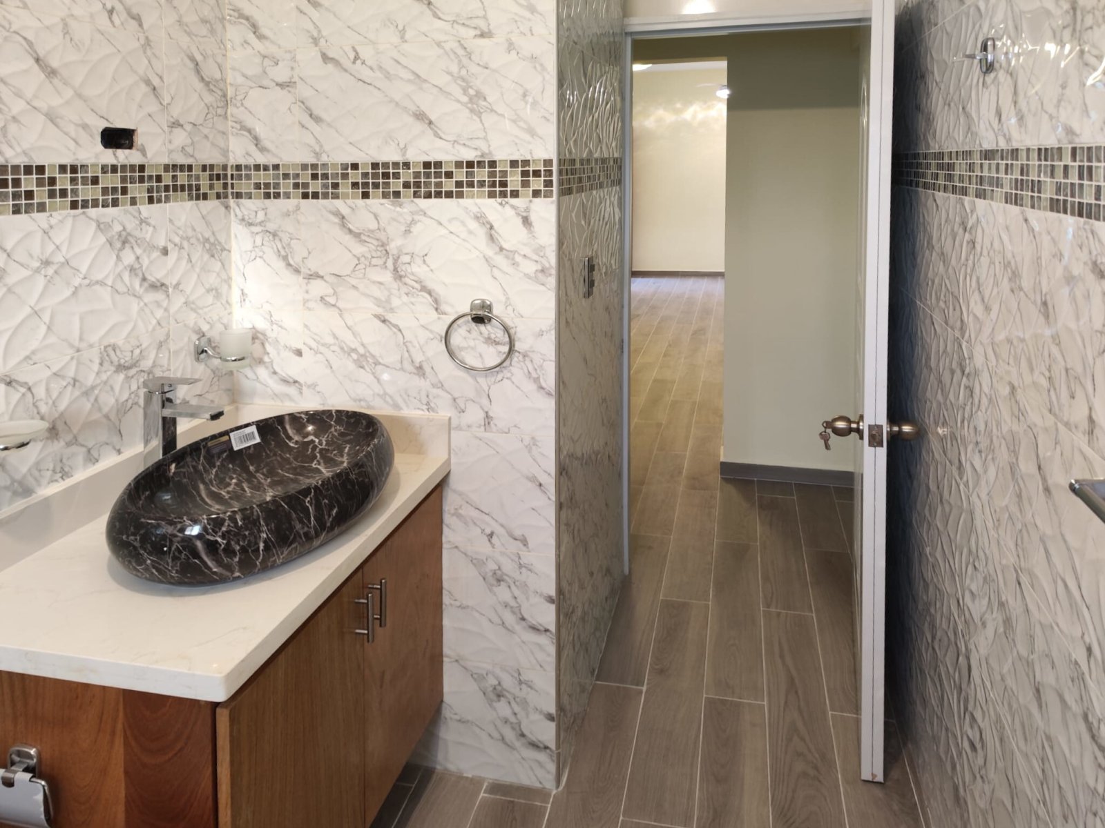 Elegant bathroom with marble wall covering and walk-in shower Elegant bathroom with marble wall covering and walk-in shower