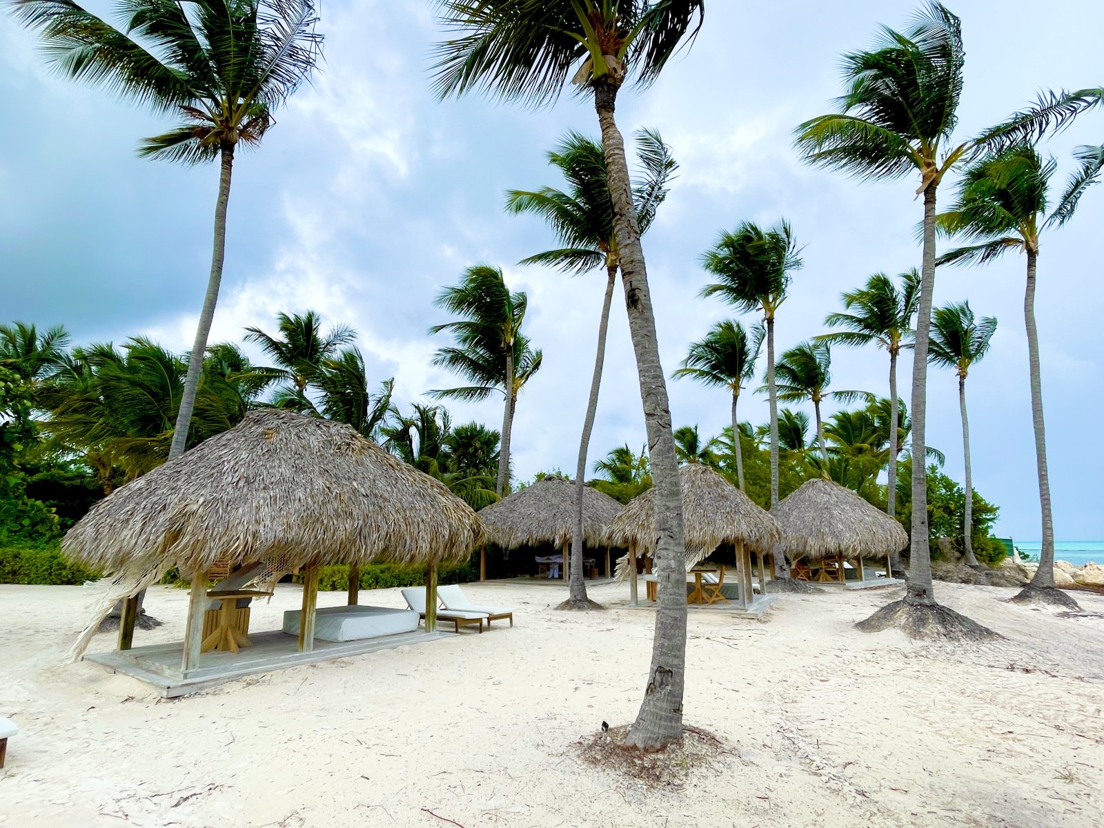 Beach pavilions with authentic thatched roof architecture and palm garden Beach pavilions with authentic thatched roof architecture and palm garden