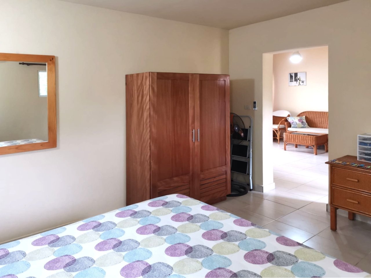 Spacious master bedroom with direct access to the adjacent area and practical tiled flooring