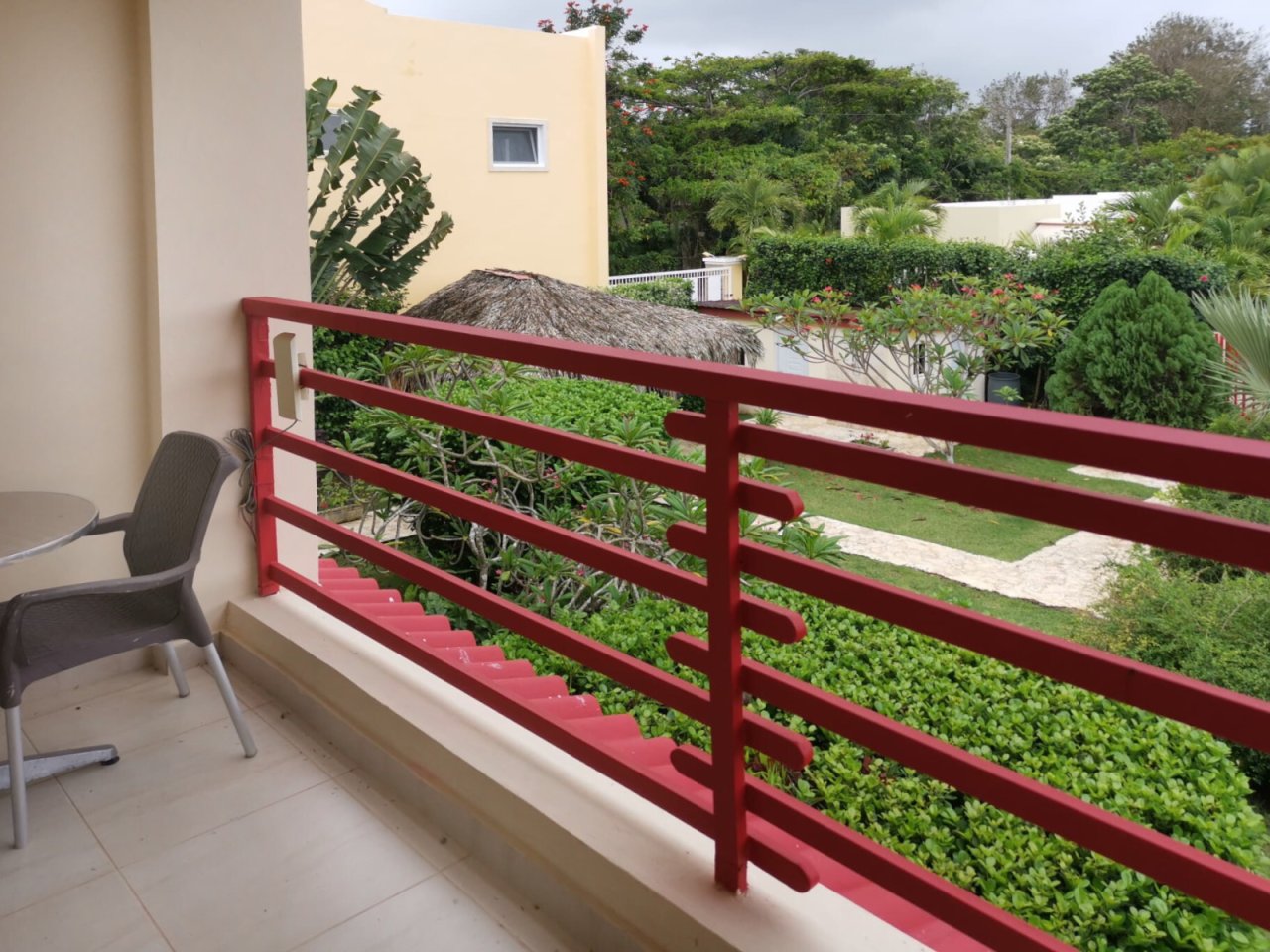 Private balcony with panoramic view of the garden area and sturdy metal railing construction
