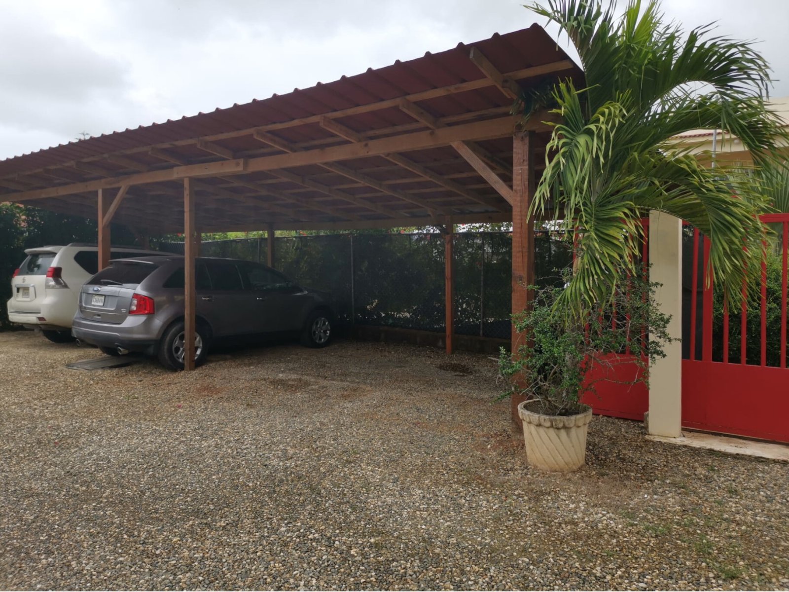 Covered carport with sturdy wooden construction and space for multiple vehicles