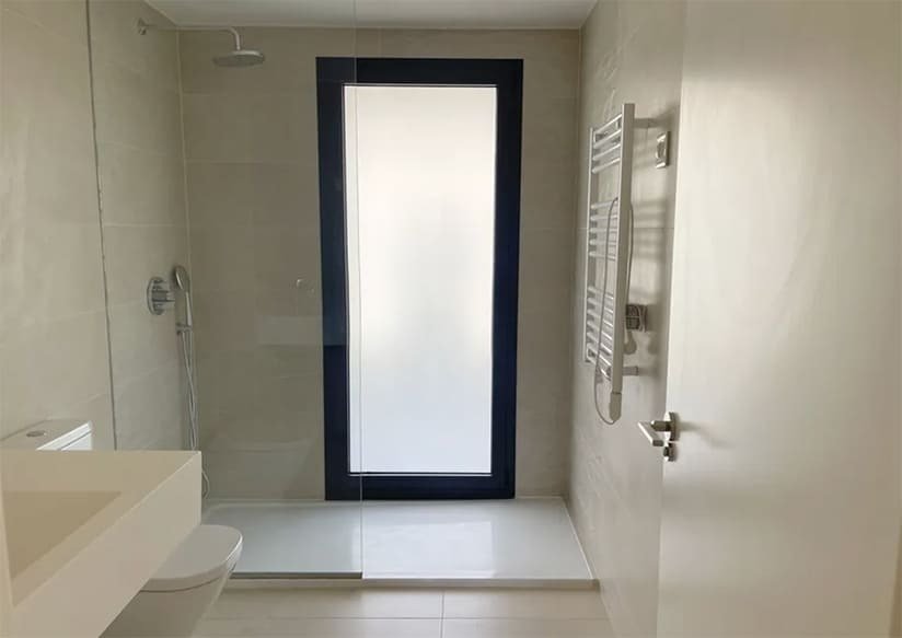 Modern bathroom with walk-in shower, heat lamp, and large window front for optimal brightness Modern bathroom with walk-in shower, heat lamp, and large window front for optimal brightness