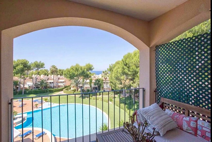 Elegant loggia with curved architecture and unobstructed views of the pool area and the sea.