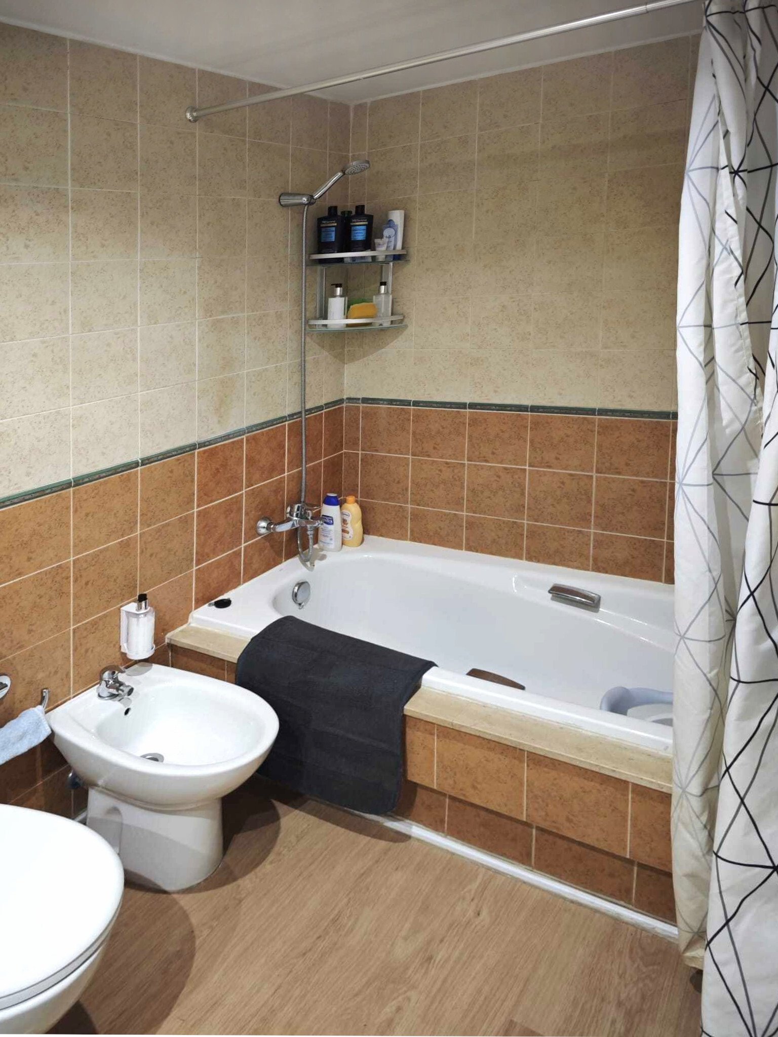 Functional bathroom with bathtub, shower, and practical shelves