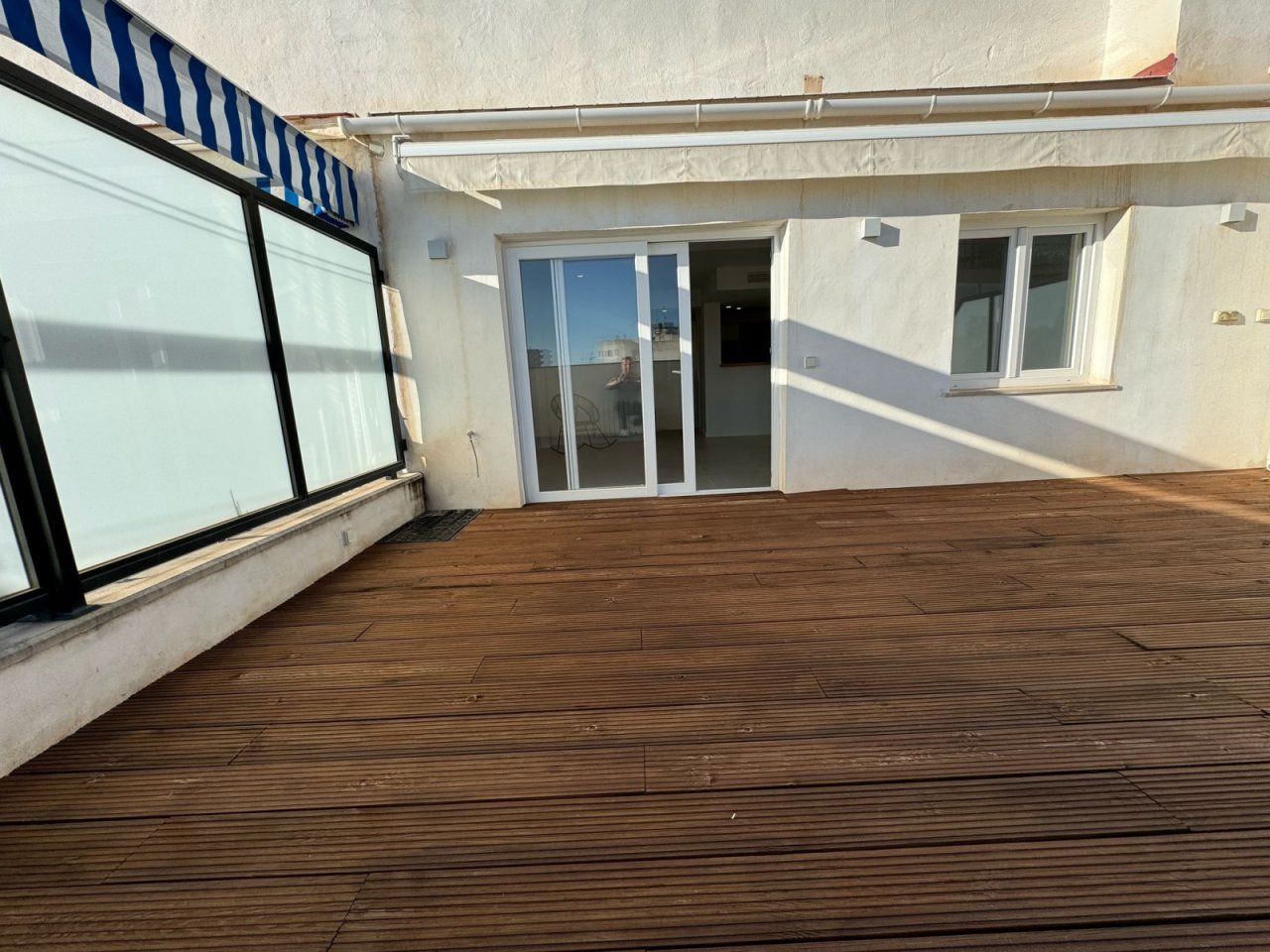Sunlit terrace with high-quality awning system and direct apartment entrance
