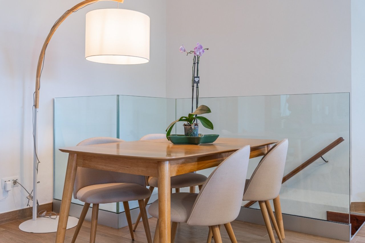 Elegant dining area with floor-to-ceiling glass partition and optimal lighting design