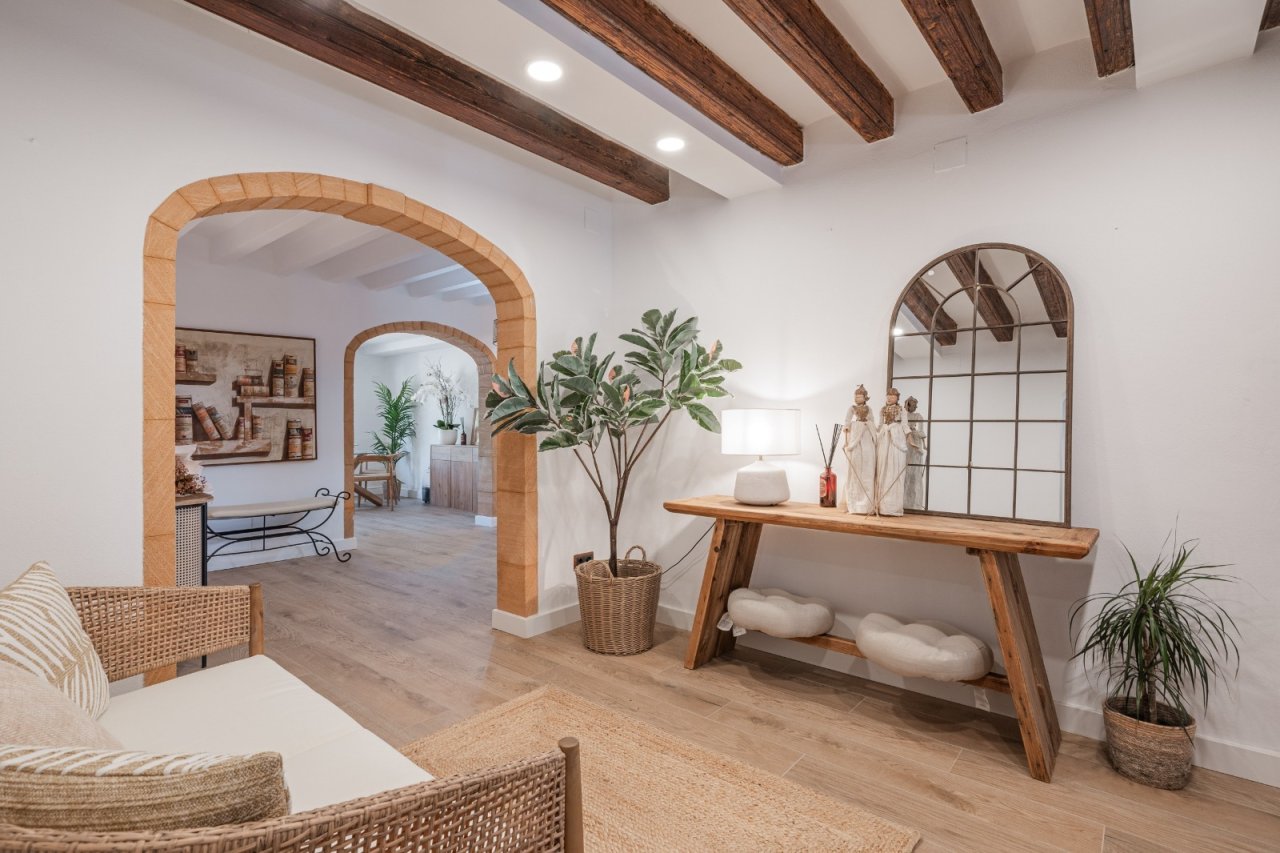 Characterful living area with solid ceiling beams and elegant stone arch openings